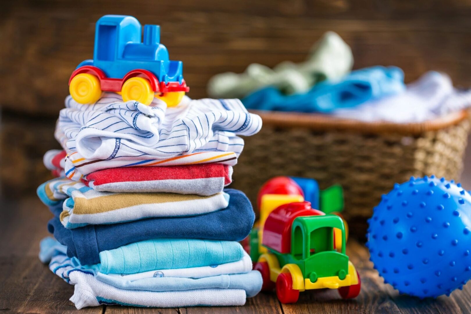A stack of folded clothes next to toy train.