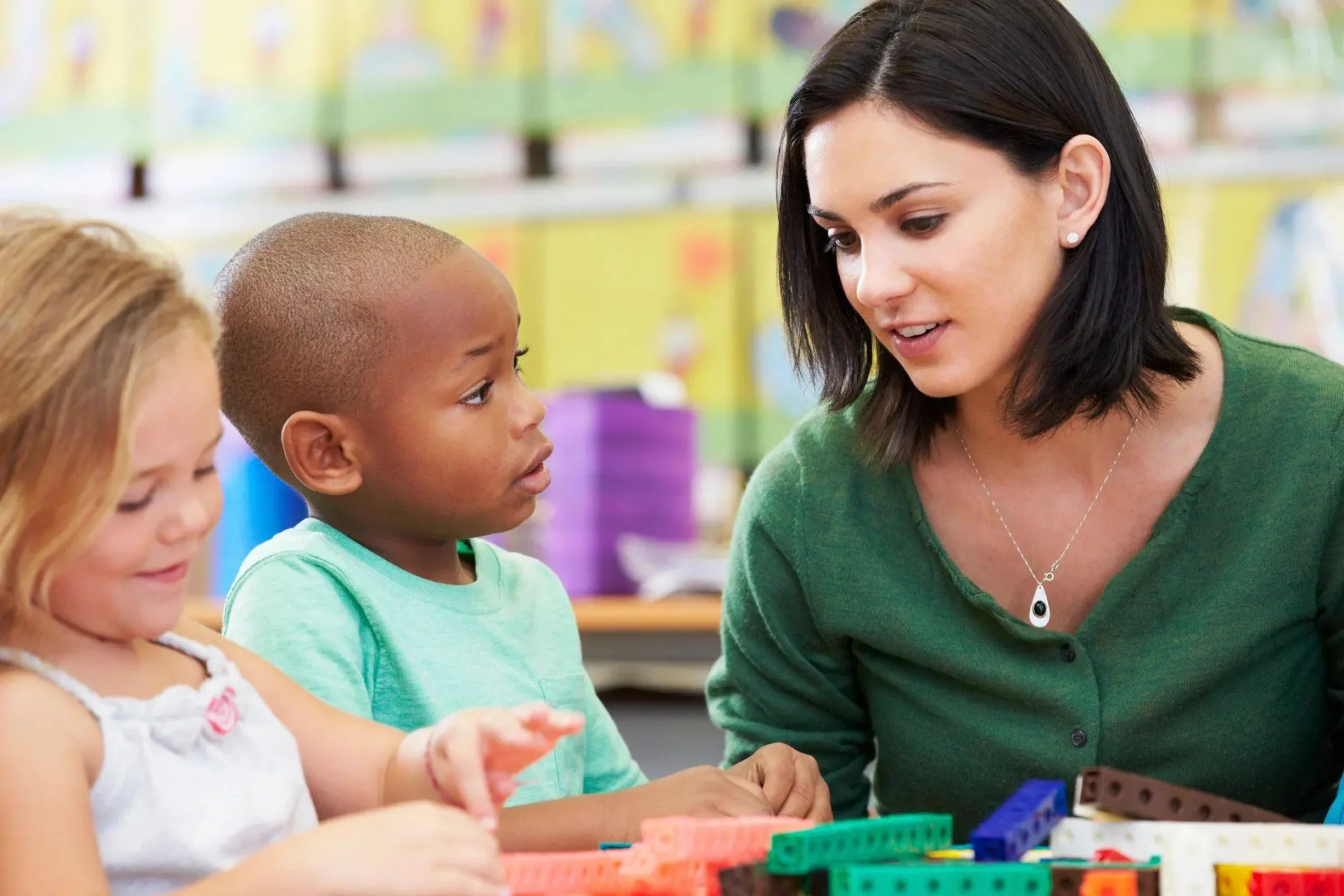 nanny playing with children and teaching them with classroom tools