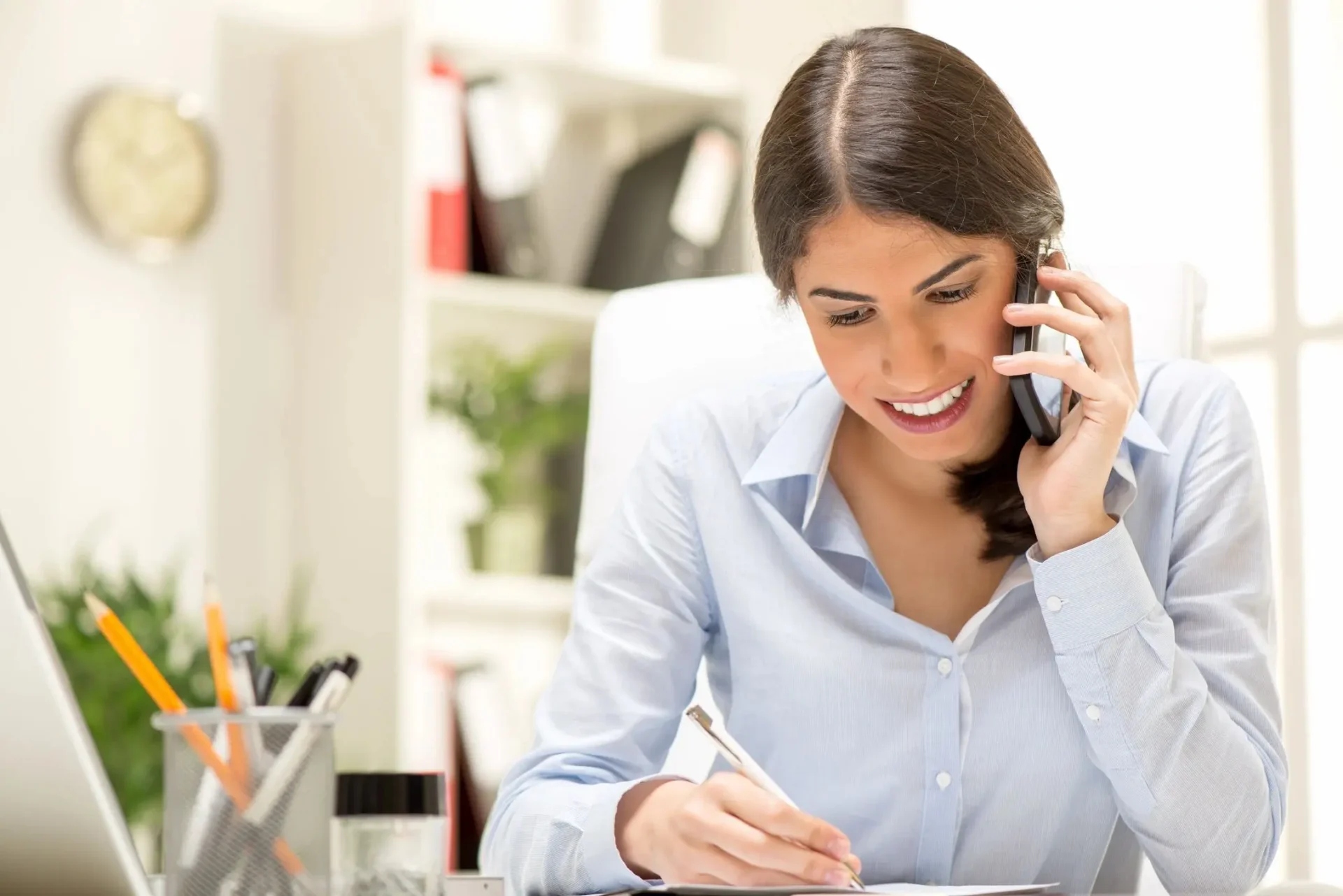 choice-care-screening-and-standards woman talking phone and writing on a paper pad with a pen