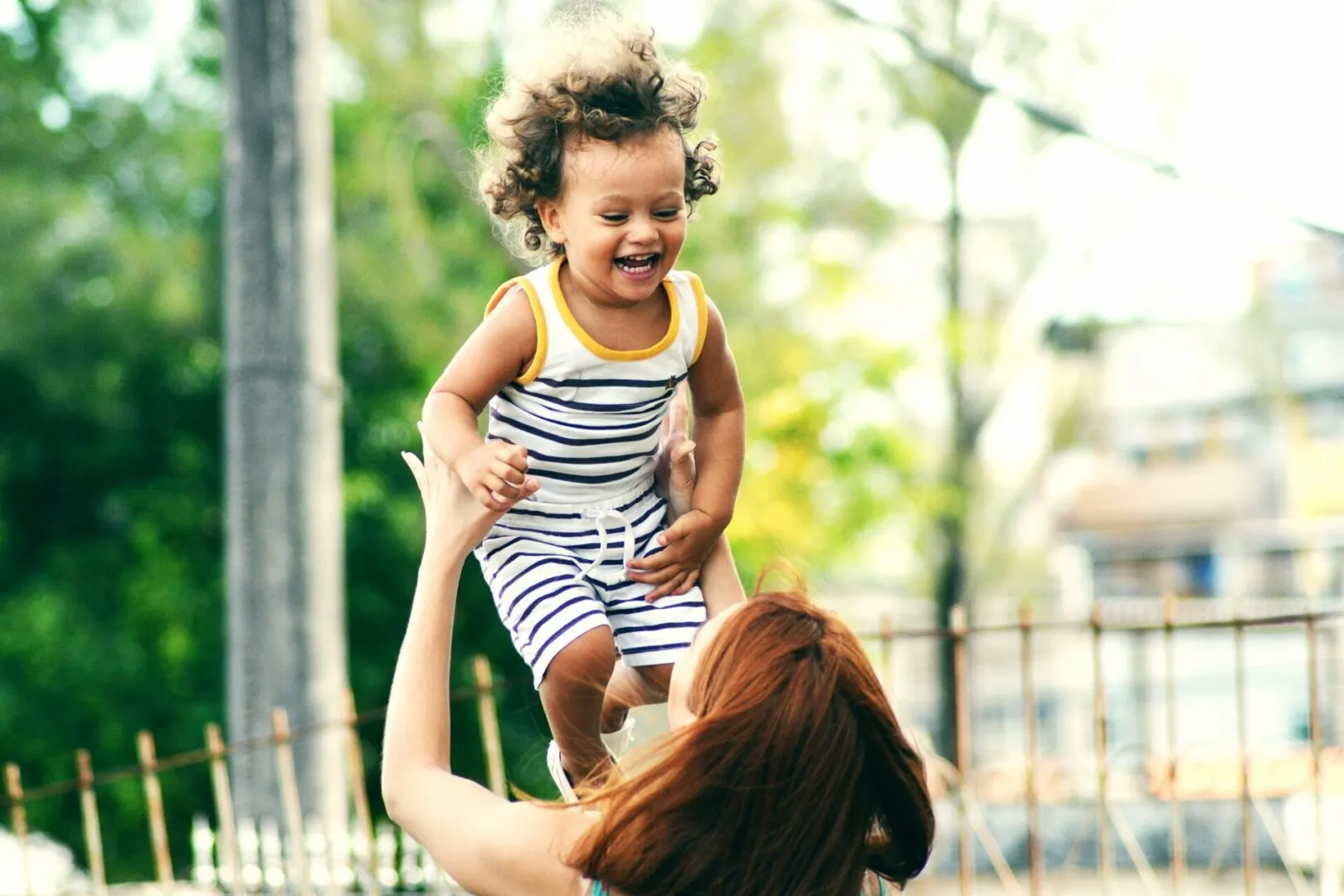 nanny playing with child and making them laugh by tossing them in the air with care